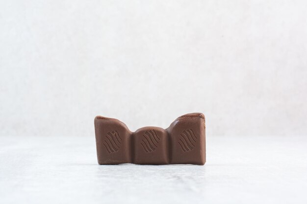 Morceau de barre de chocolat sur fond de pierre. photo de haute qualité