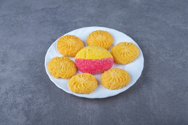 Un morceau de biscuit et de biscuit en forme de pêche sur une assiette sur une table en marbre.