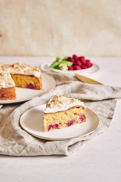 Morceau du délicieux gâteau aux framboises avec baiser sur une assiette