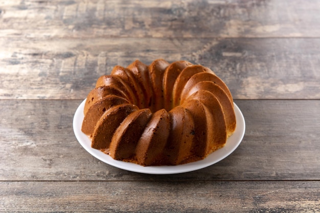 Photo gratuite morceau de gâteau bundt traditionnel aux raisins secs sur table en bois