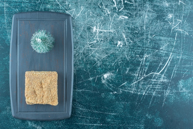 Photo gratuite un morceau de gâteau savoureux avec petit arbre de noël sur une assiette sombre. photo de haute qualité