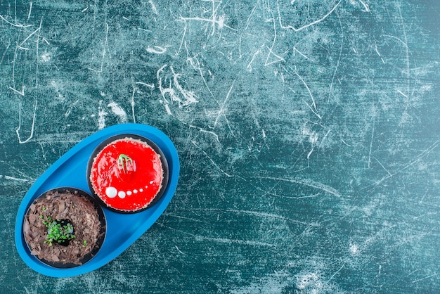 Morceau de gâteaux au chocolat et aux fraises sur plaque bleue.