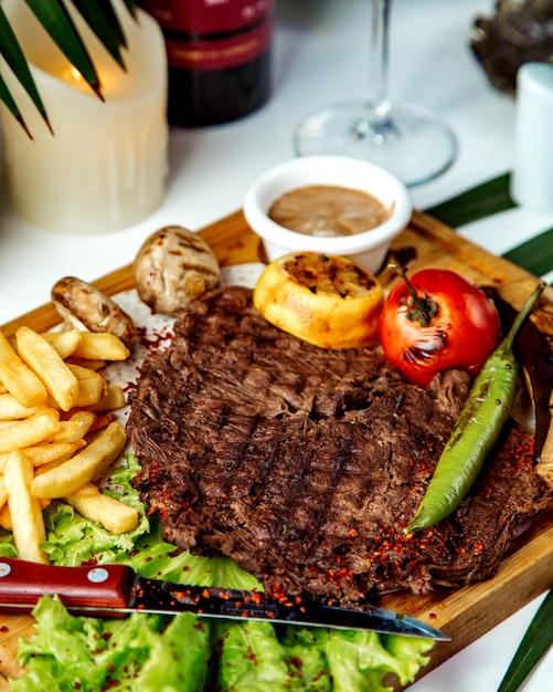 Morceau de viande frite avec frites et légumes