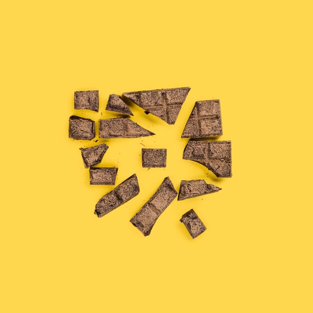 Des morceaux de chocolat écrasés sur une surface jaune