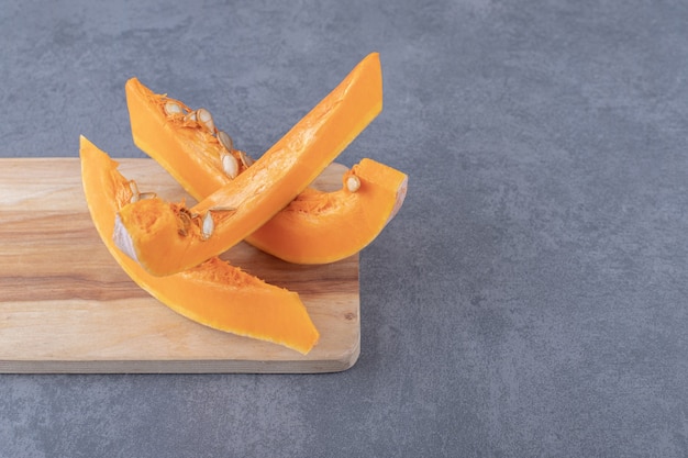 Morceaux de courgettes savoureux sur le plateau, sur la surface en marbre.