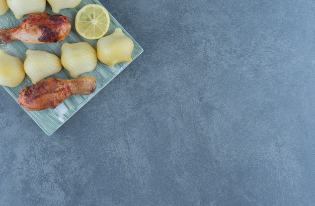 Photo gratuite morceaux de poulet grillés et pommes de terre bouillies sur planche de bois.