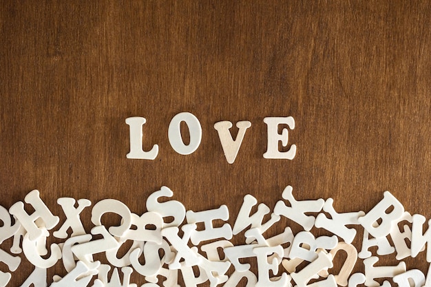 Photo gratuite le mot amour fait de lettres en bois sur un fond en bois vue supérieure