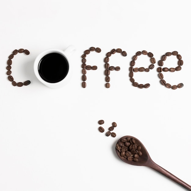 mot "café" écrit avec des grains de café torréfiés et une cuillère