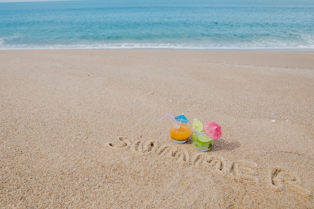 Mot écrit sur le sable et les cocktails