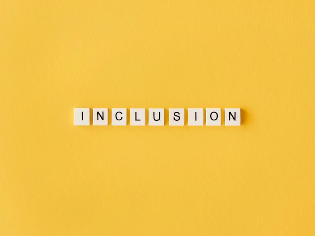 Mot d'inclusion écrit en lettres de scrabble sur fond jaune