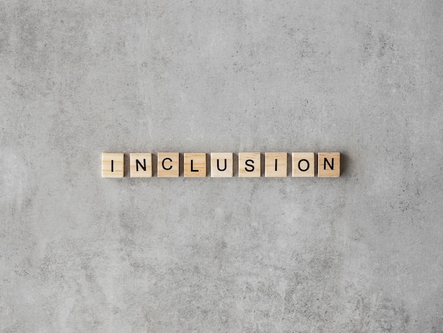 Photo gratuite mot d'inclusion écrit en lettres de scrabble sur fond de marbre