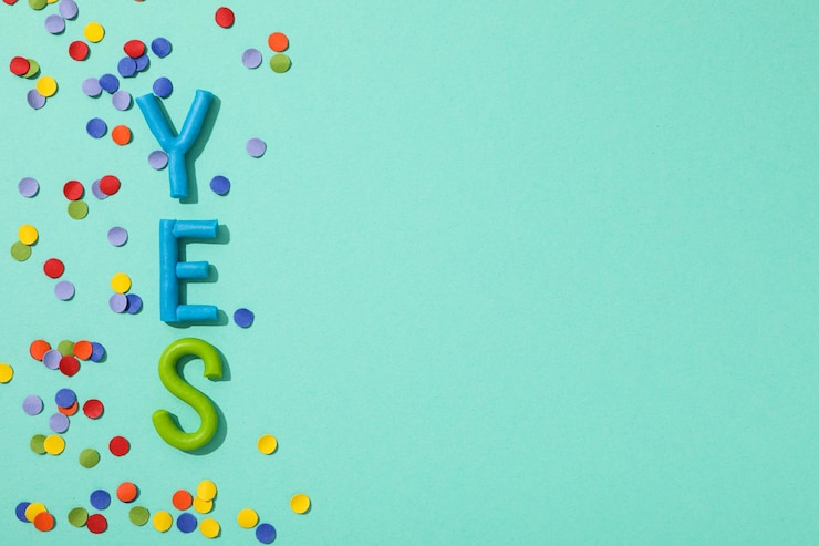 Photo gratuit le mot " oui " est fait de plasticine colorée sur un fond turquoise