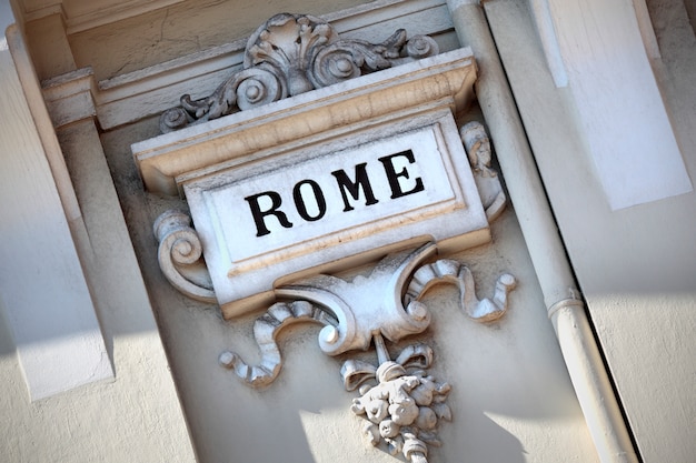 Le mot Rome gravé dans un vieux mur sculpté.