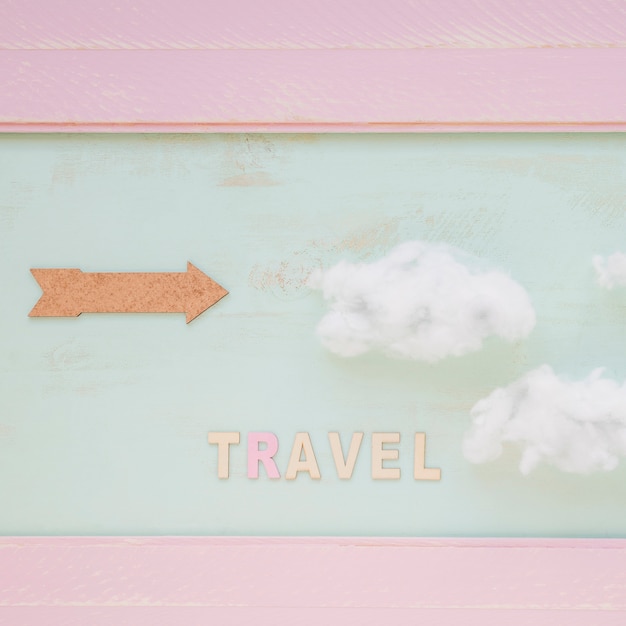 Mot de voyage avec les nuages ​​et la flèche contre le mur peint