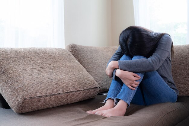 Émotionnelle jeune femme était déprimée sur un canapé