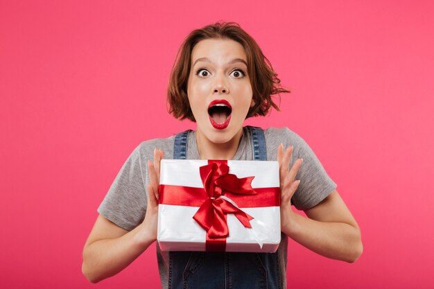 Émotionnelle jeune femme tenant une boîte-cadeau.