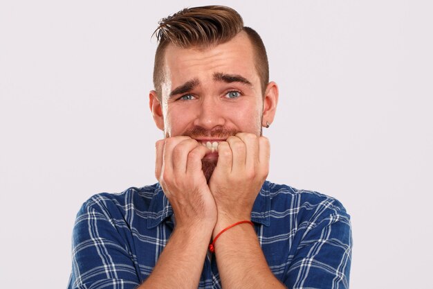 Émotions. Jeune homme en chemise bleue