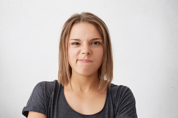 Émotions négatives, mécontentement. Femme offensée maussade, courbant ses lèvres à l'insatisfaction