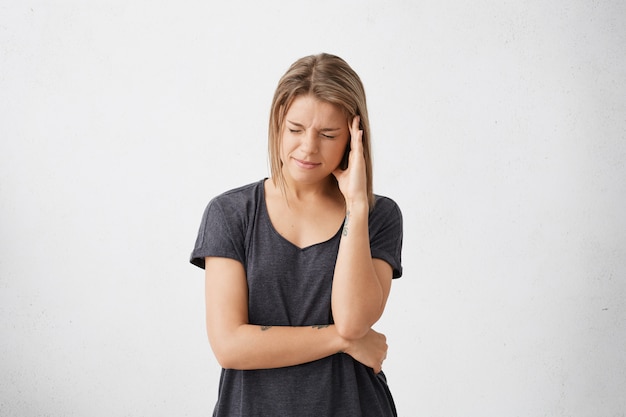 Émotions et sentiments humains négatifs. malheureuse jeune femme souffrant de maux de tête ou de migraine