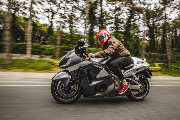 Moto à grande vitesse sur la route à travers la forêt