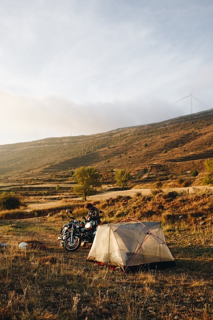 Motocycliste d'aventure en camping sauvage