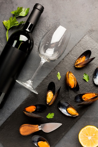 Moules cuites à plat et bouteille de vin