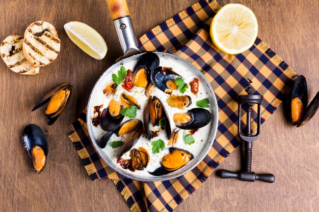 Moules plates en sauce blanche sur nappe