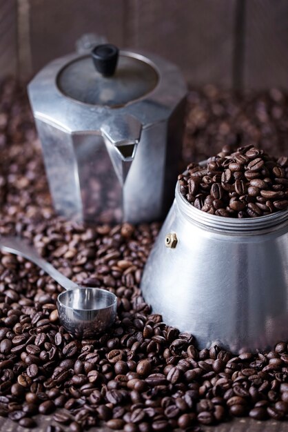 Moulin à café à l'ancienne et cuillère parmi les grains de café