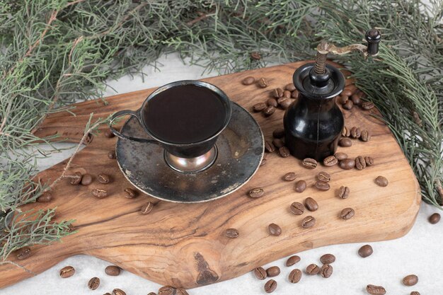 Moulin à café, haricots et arôme de café sur planche de bois