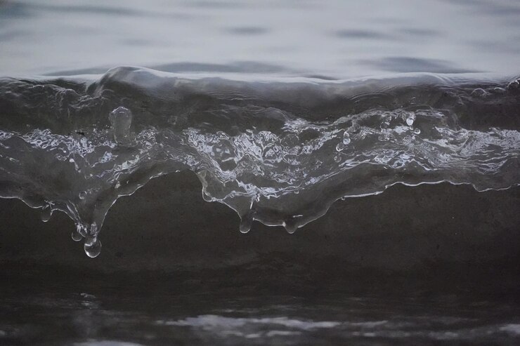 Photo gratuit la mousse blanche et la goutte d'eau de mer éclaboussent au ralenti avec du sable et de l'eau bleue.