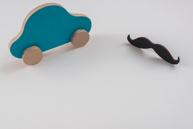 Moustache noire avec petite voiture sur la table