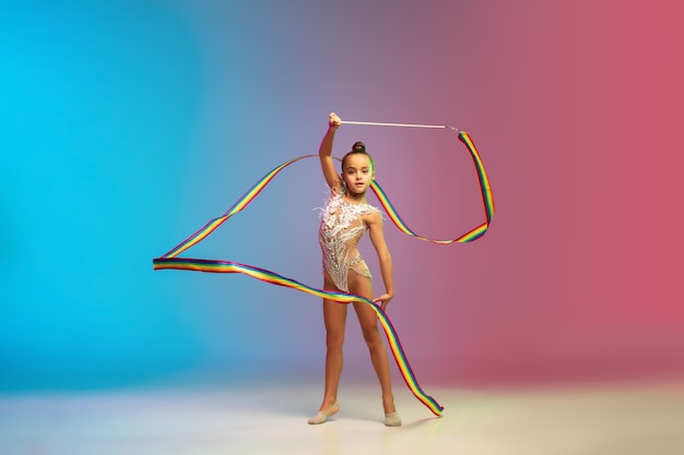 Mouvement. Petite fille caucasienne, formation de gymnaste rythmique, exécution isolée