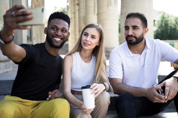 Photo gratuite moyenne coups amis multiculturels prenant selfies