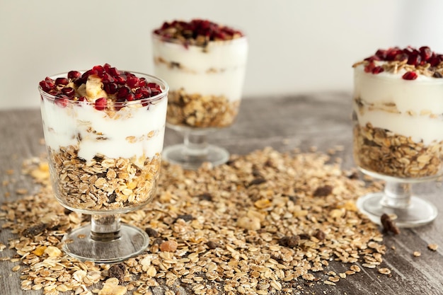 Muesli avec flocons d'avoine et grenade sur le dessus sur fond de bois