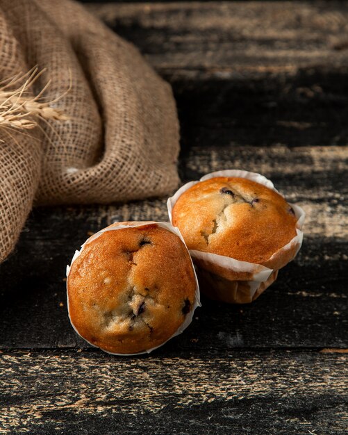 Photo gratuite muffins au cassis avec cassis et blé sur table