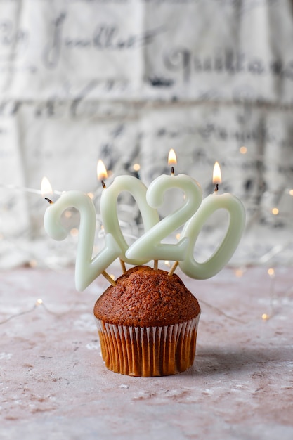 Muffins au chocolat sur les meilleures bougies 2020 sur une surface marron clair