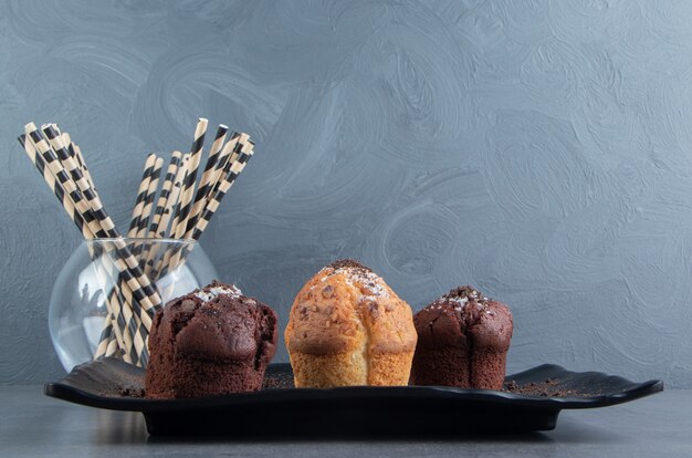 Muffins au chocolat avec muffin aux noix sur une planche noire