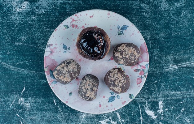 Photo gratuite muffins au chocolat savoureux sur la plaque, sur le fond bleu