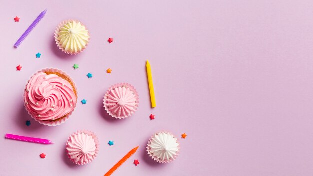 Muffins; bougies; aalaw et pépite sur fond rose