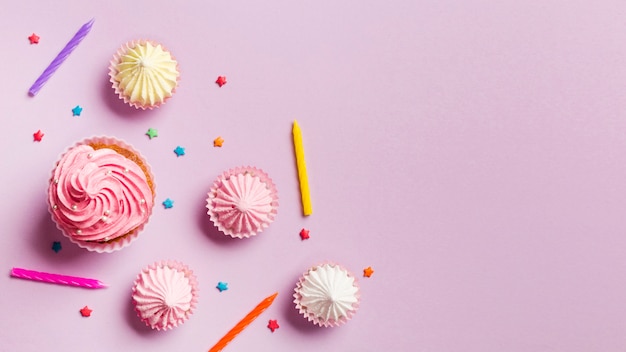 Muffins; bougies; aalaw et pépite sur fond rose