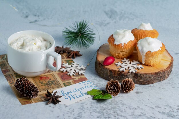 Muffins crémeux faits maison sur une surface en bois avec du chocolat chaud.