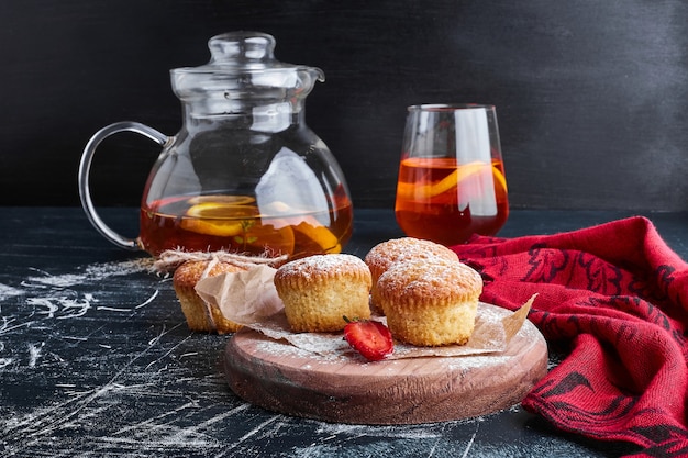 Muffins sur une planche de bois avec un verre de boisson.