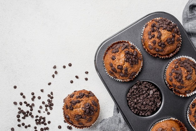 Muffins sur une plaque à pâtisserie et pépites de chocolat