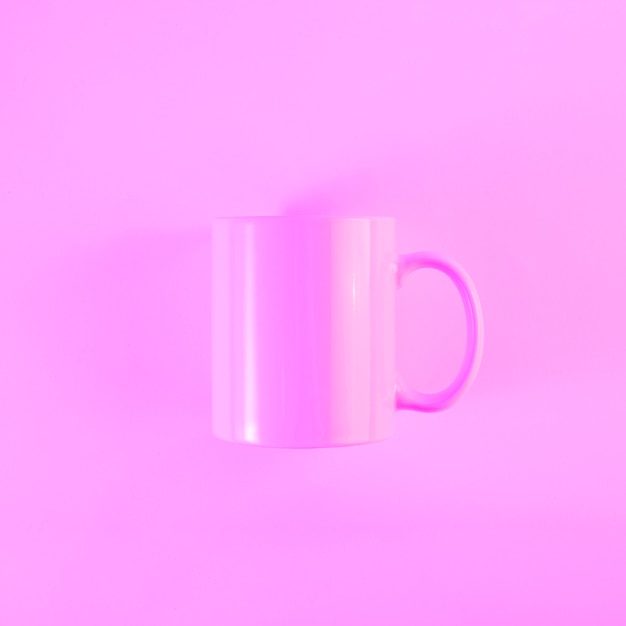 Mug rose peint avec poignée sur fond coloré