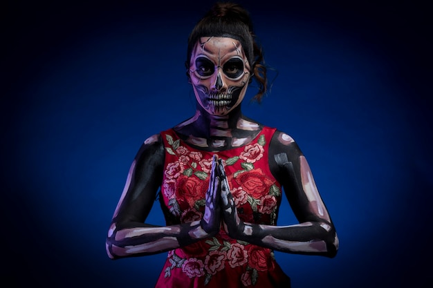 Mujer Con Body Paint De Calavera Con Vestido Rojo Y Fondo Azul Por Dia De Muertos Photo Premium