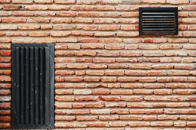 Mur de barrage en brique avec fond publicitaire de grilles de ventilation ou économiseur d'écran de papier peint