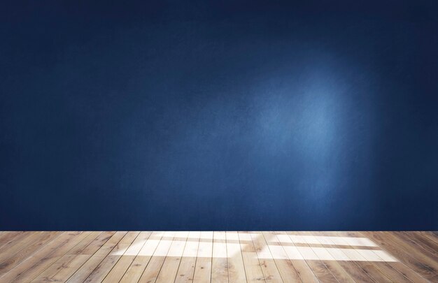 Mur bleu foncé dans une pièce vide avec un plancher en bois