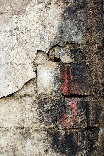 Mur de ciment avec des briques sales exposées et de la peinture