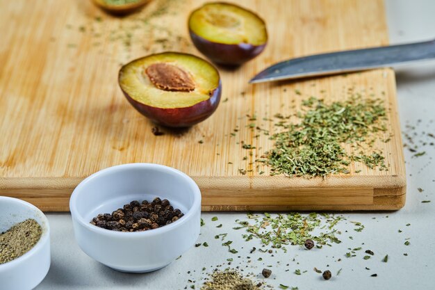 Mûr demi-coupe de prune sur planche de bois avec des épices.