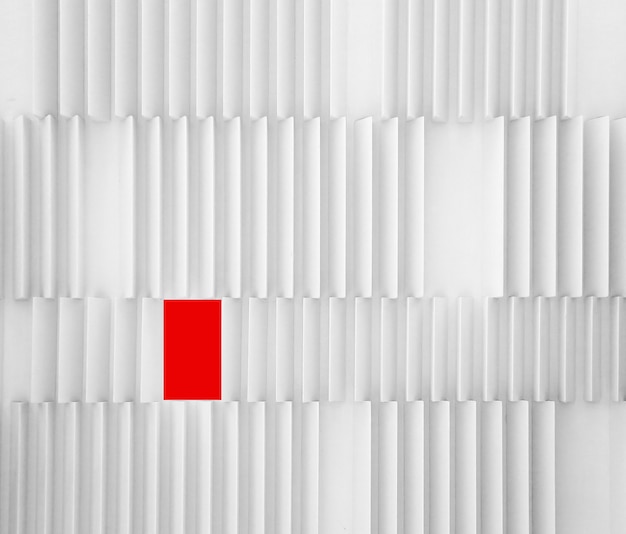 Un mur moderne texturé blanc froid avec un rectangle de forme différente rouge - concept de diversité